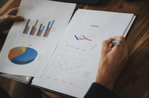 Over the shoulder view of a businesswoman reviewing business and economic report